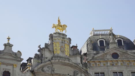 golden statue of rider on the roof of the brewers' house at grande place - brussels, belgium