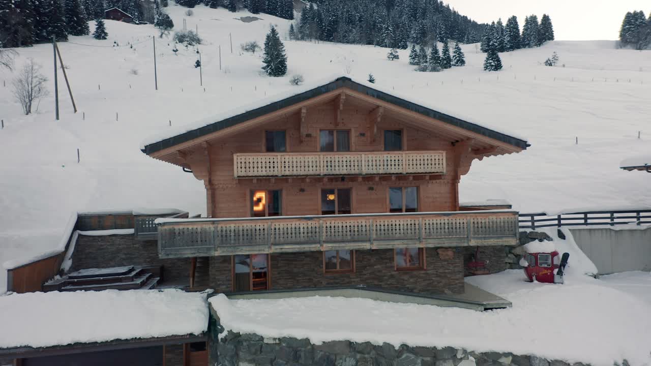 descripción aérea de un lujoso chalet en un paisaje cubierto de nieve.