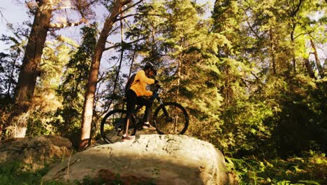 Excited-mountain-biking-couple-standing-on-a-rock