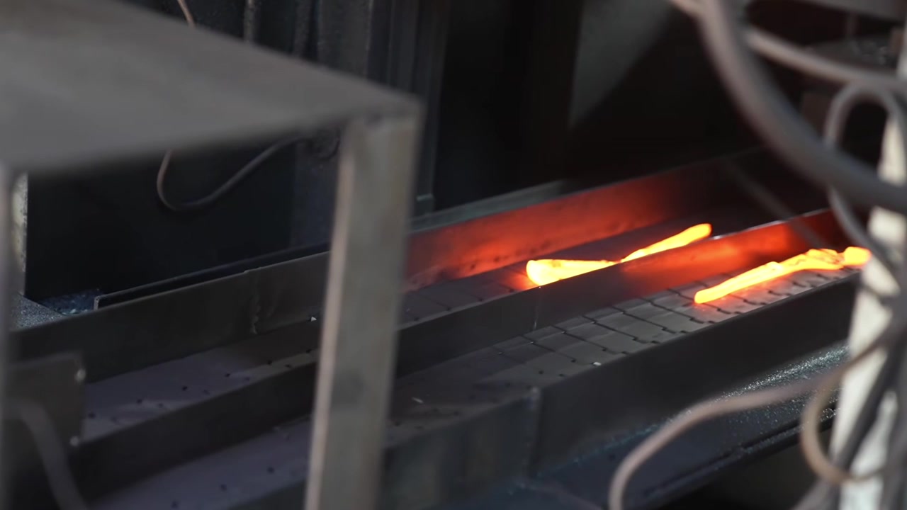 Heated steel blanks glowing bright orange inside industrial induction heating furnace