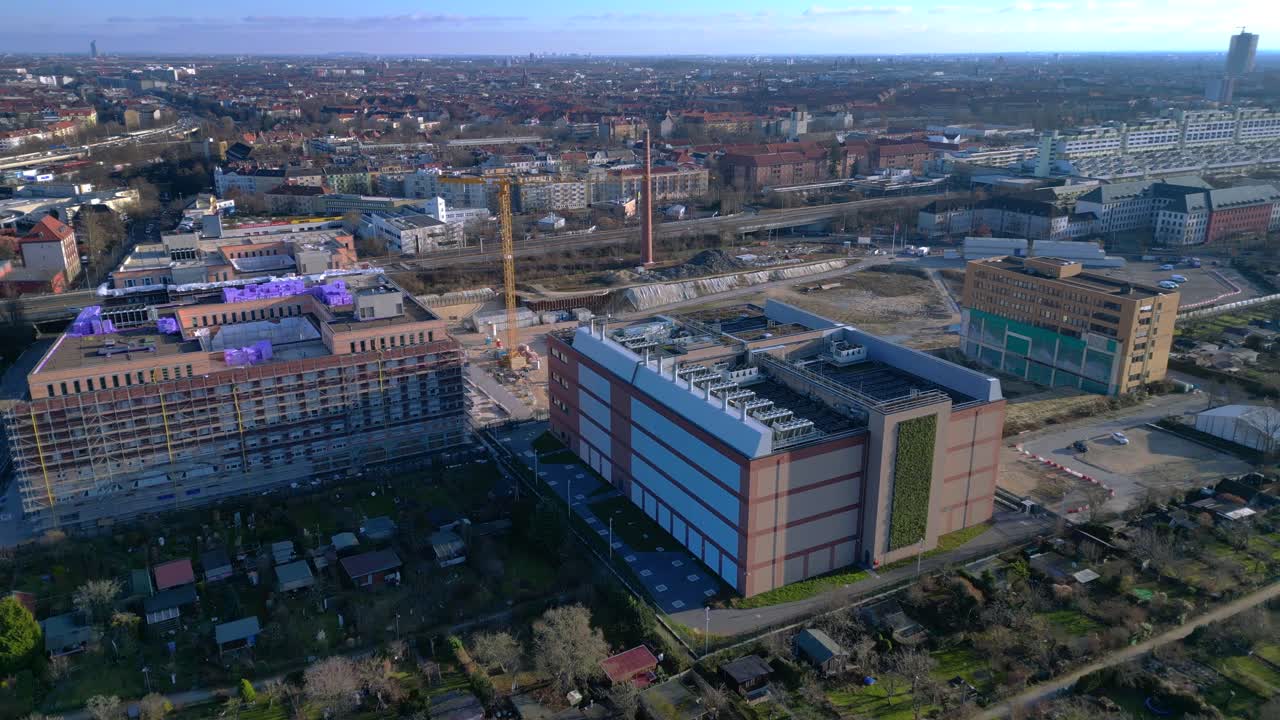 Moderno edificio di datacenter con una facciata a parete verde, che rappresenta l'infrastruttura tecnologica e l'informatica sostenibile in un paesaggio urbano. Panorama aereo unico con drone orbitale.