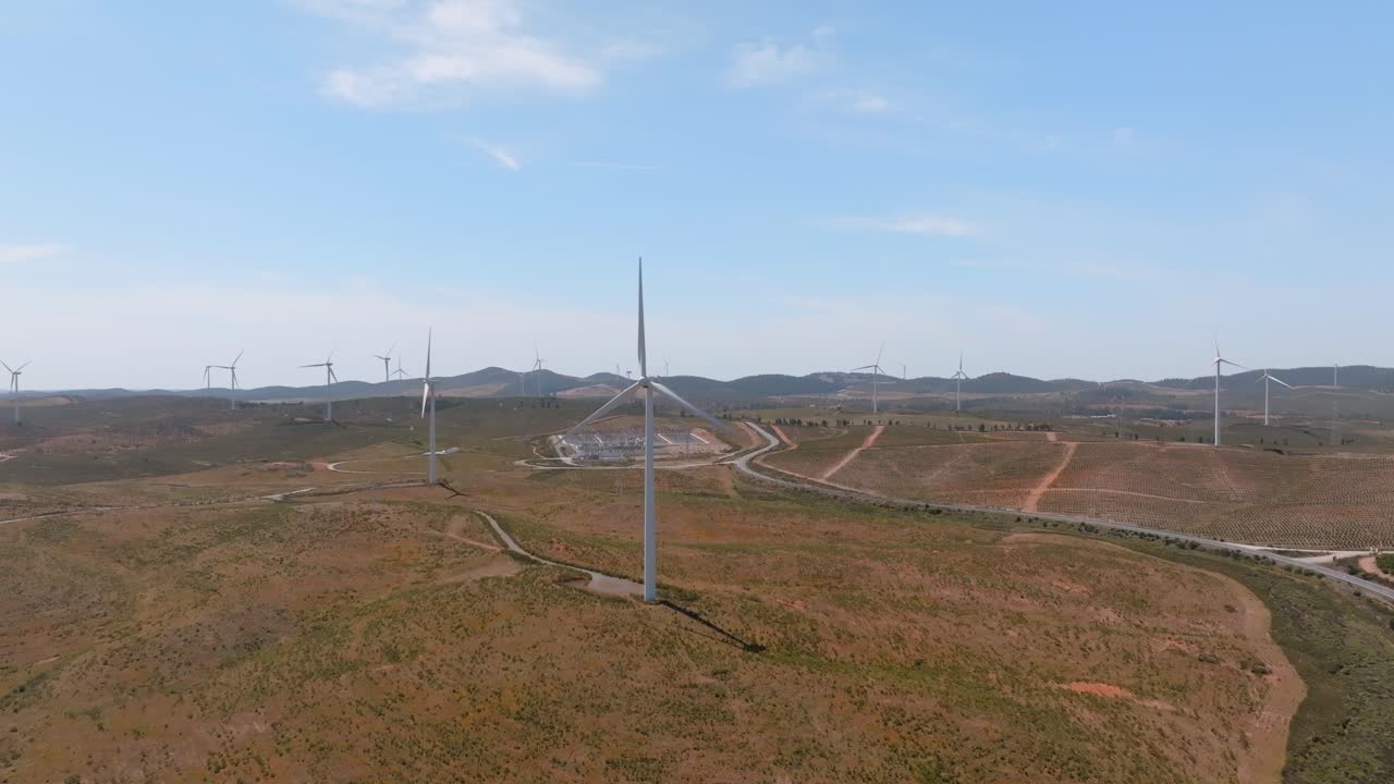 visión general panorámica de drones dolly hacia las turbinas eólicas a través del paisaje desértico