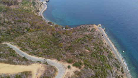 drone shot overlooking sloping cliffs of lovers cove turquoise blue ocean, catalina island