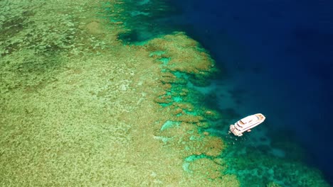 yate solitario atracado a la vista de la gran barrera de coral - toma aérea