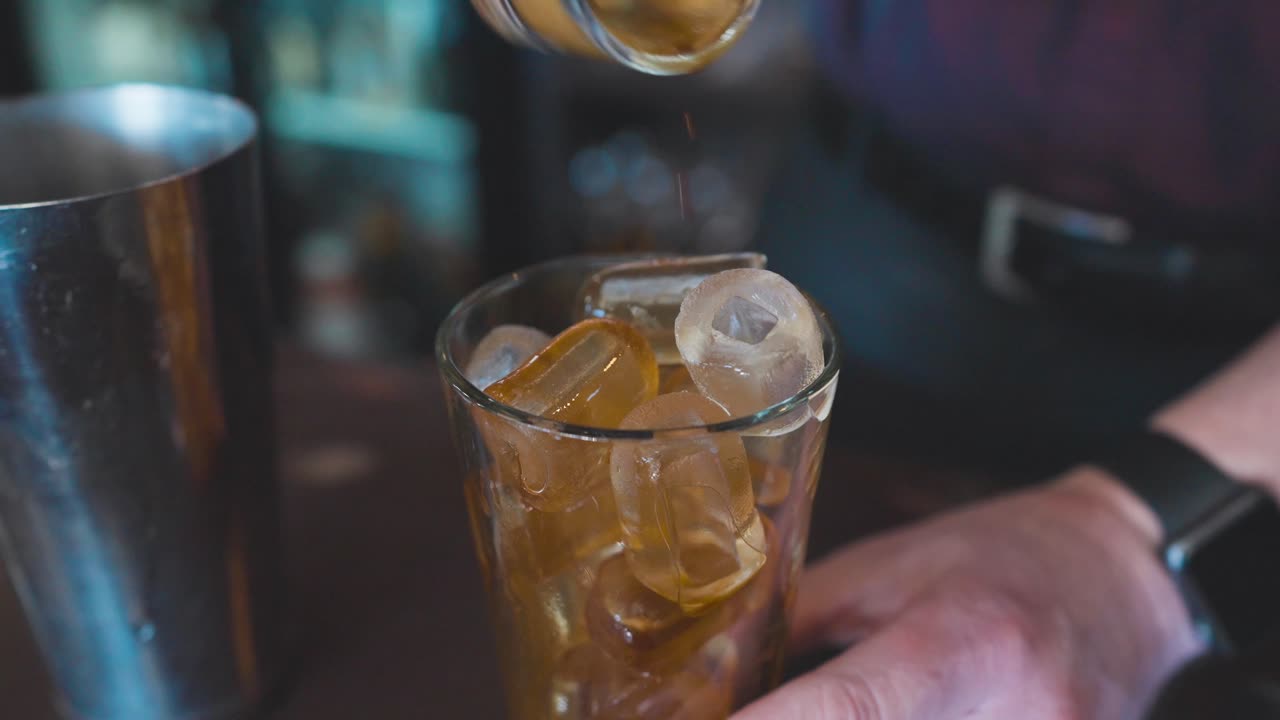 café vertido en una coctelera de vidrio llena de cubitos de hielo para hacer un cóctel espresso martini