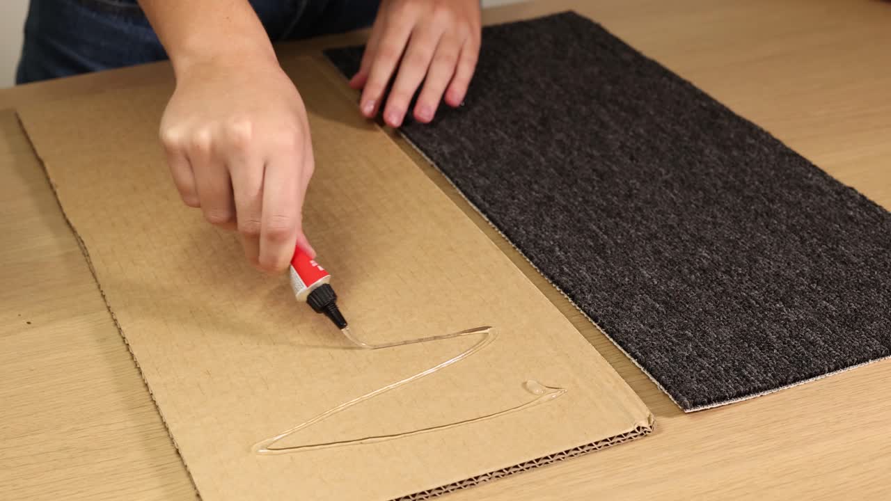 Hands applying adhesive and attaching carpet to cardboard. Step-by-step process with clear, bright lighting and close-up shots