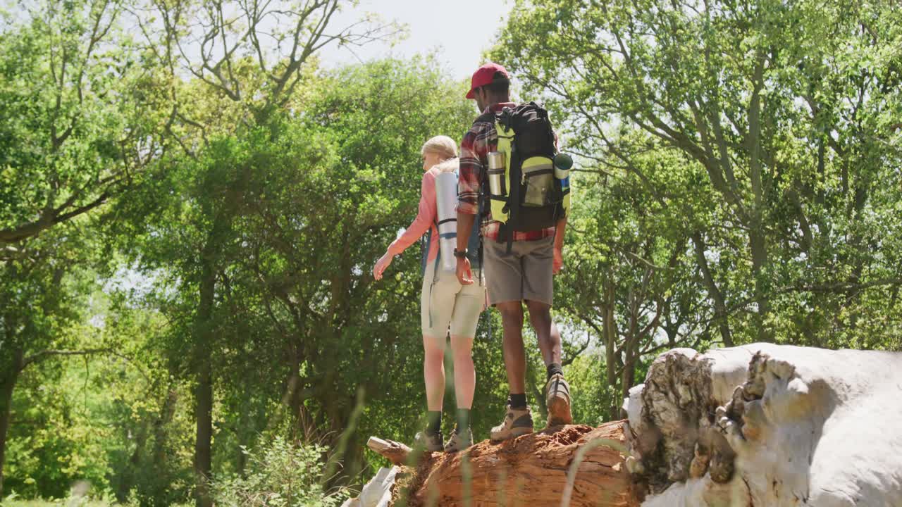 pareja feliz caminando con mochilas en el parque, cámara lenta