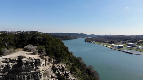 aerial austin pennybacker bridge - flying low off the ledge towards the other side of the overlook. panning right to reveal the river and the austin skyline in the far distance.