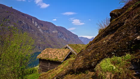 Peaceful-view-of-a-structure-of-a-old-wooden-house-on-the-edge-of-the-mountain-range-in-timelapse-in-Norway,-Europe-on-a-bright-sunny-day