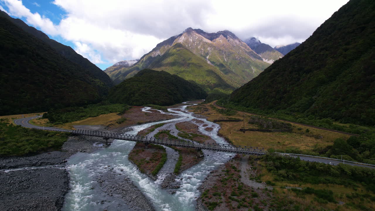 Aerial view away from a car crossing a bridge over the Otira River in New Zealand