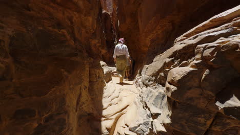 woman hiking through a narrow canyon