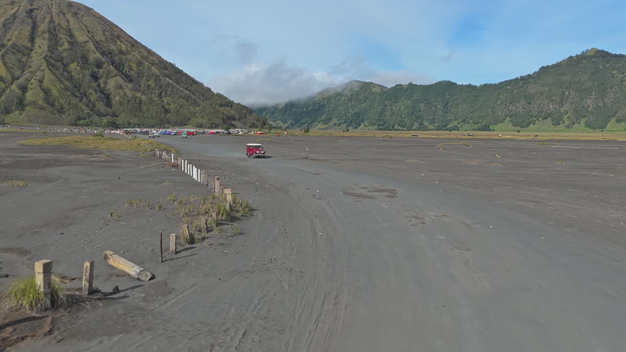 Terrængående køretøjer kører gennem sandhavet i Bromo Tengger Semeru Nationalpark.