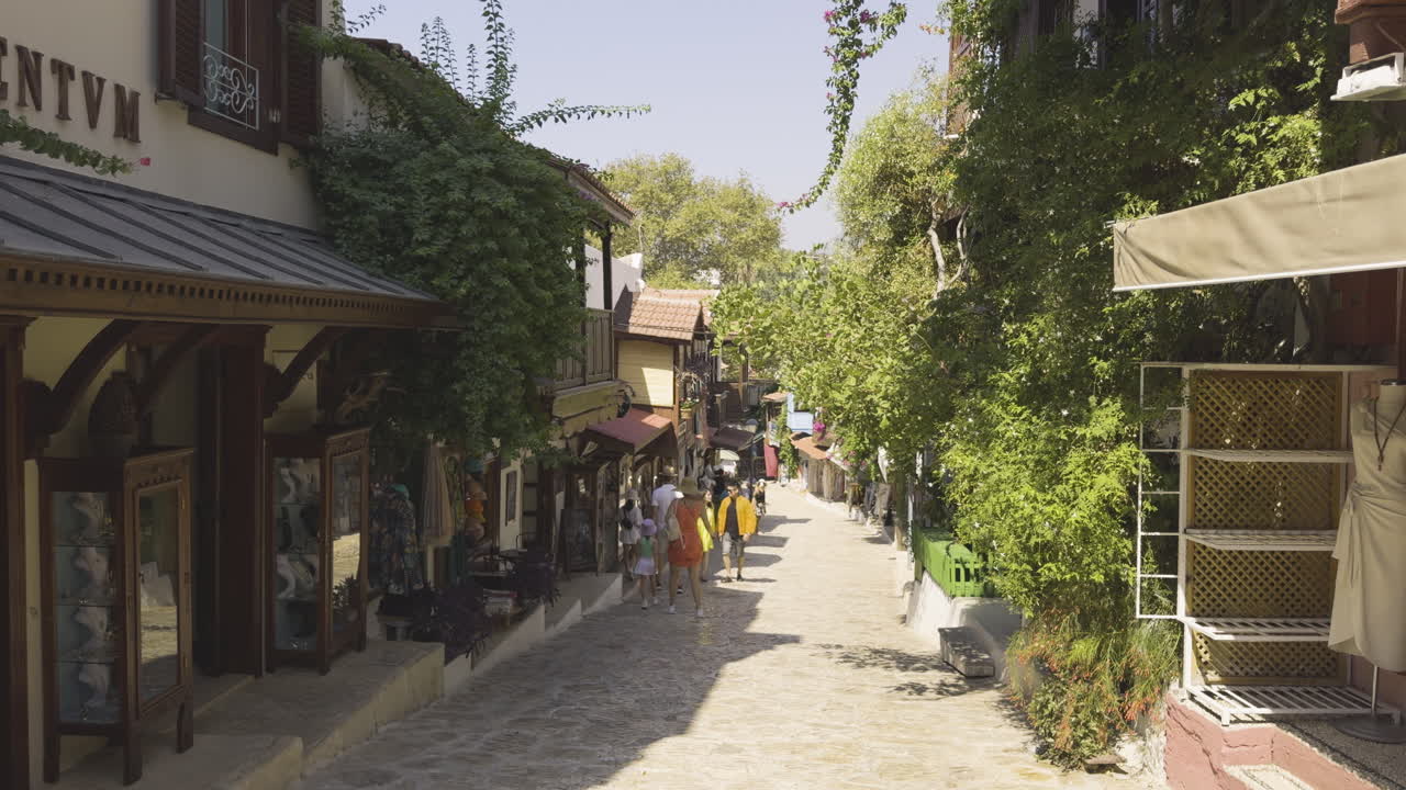 Quiet morning street in Kas, Turkey, with empty alleys and early sunlight casting shadows on stone buildings, walking POV