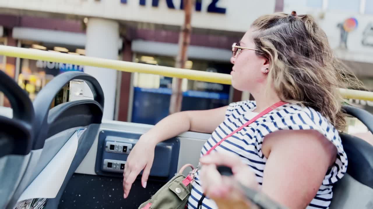 Woman Enjoying the View from a Tour Bus in Athens, Greece