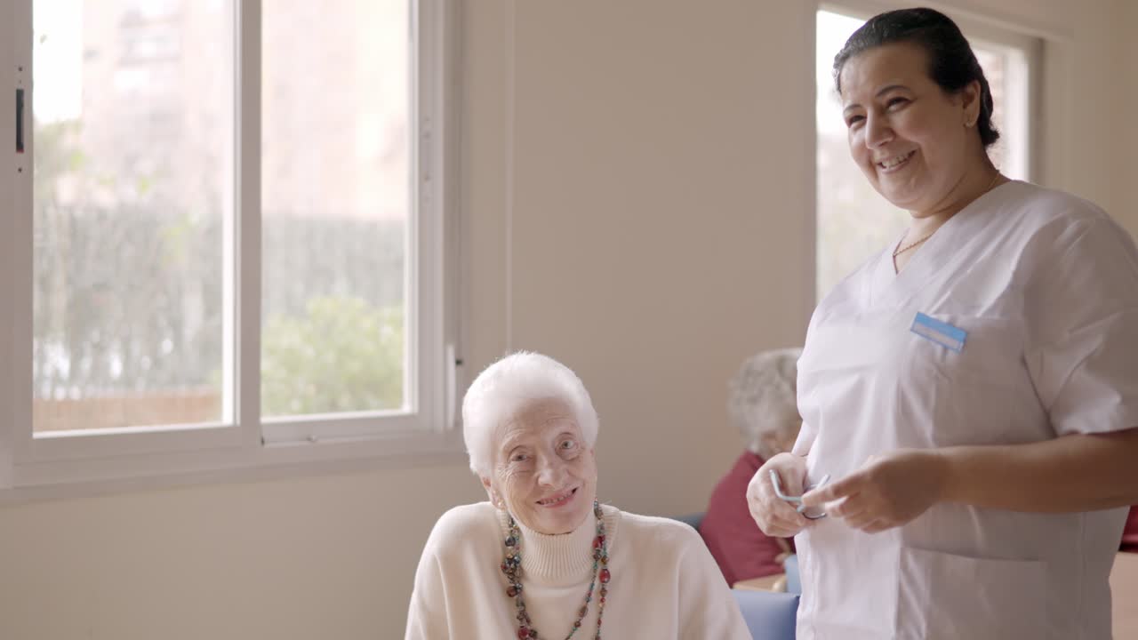 Caregiver smiling at camera next to old people in geriatric