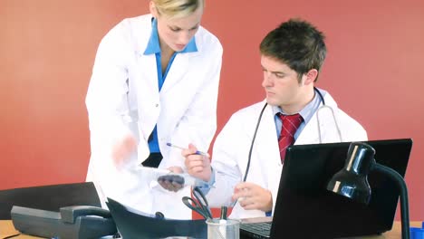 médicos hombres y mujeres firmando documentos en la oficina