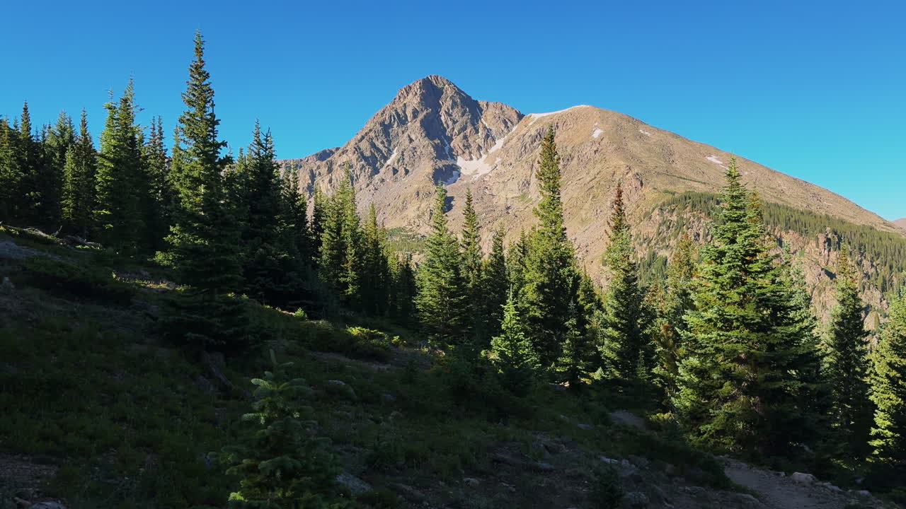 Half moon pass trailhead Mount of the Holy Cross 14er sunny prominent peak Rocky Mountain landscape Colorado morning shade Sawatch Range White river National forest spring summer blue sky zoom out