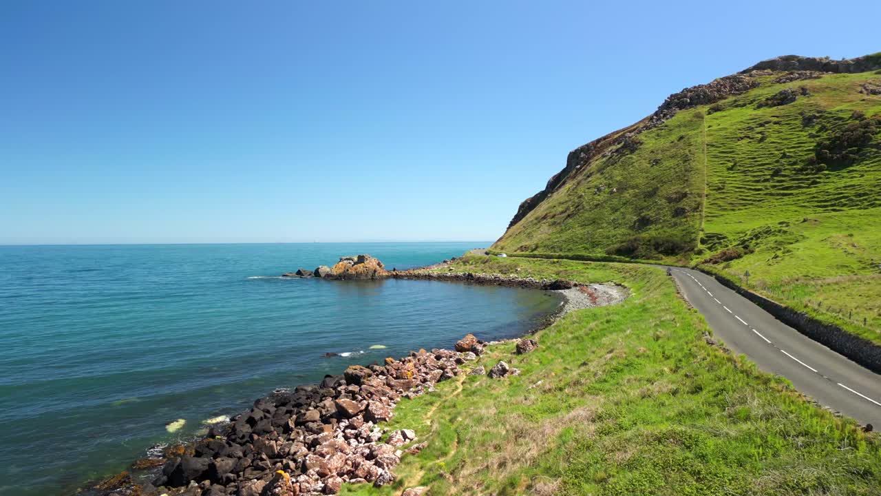 Low, forward travelling aerial video of the Antrim Coastal Route on a bright and sunny day. Filmed in Ballygally in 4K, 60FPS and with Rec800 color.
