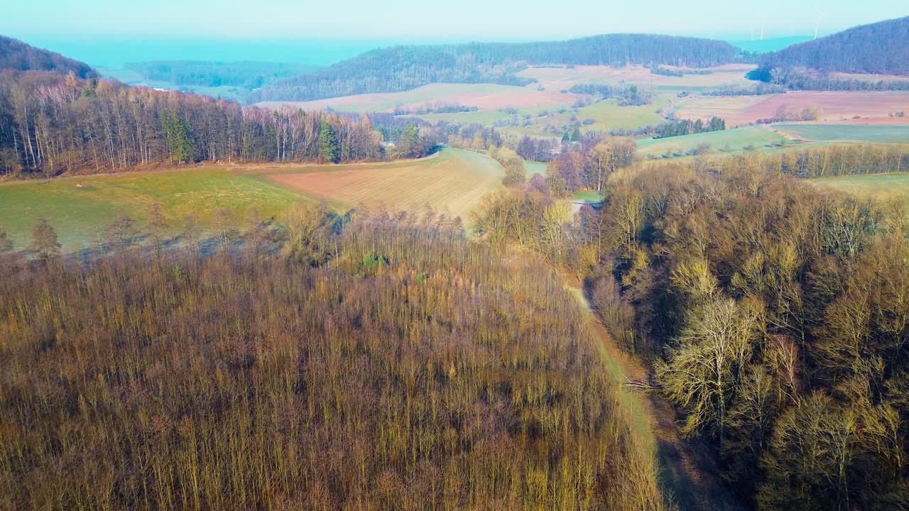 Droneudsigt over bølgende bakker og efterårsskov i skumringen