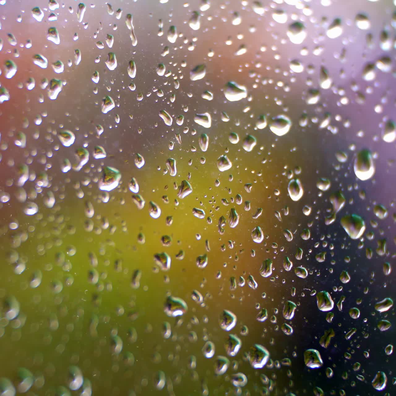 Water drops on glass window. Texture water drops on the blur colorful background. Water droplets on glass. Close-up.