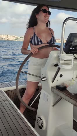 woman driving a yacht in beautiful nature landscape, at summer.