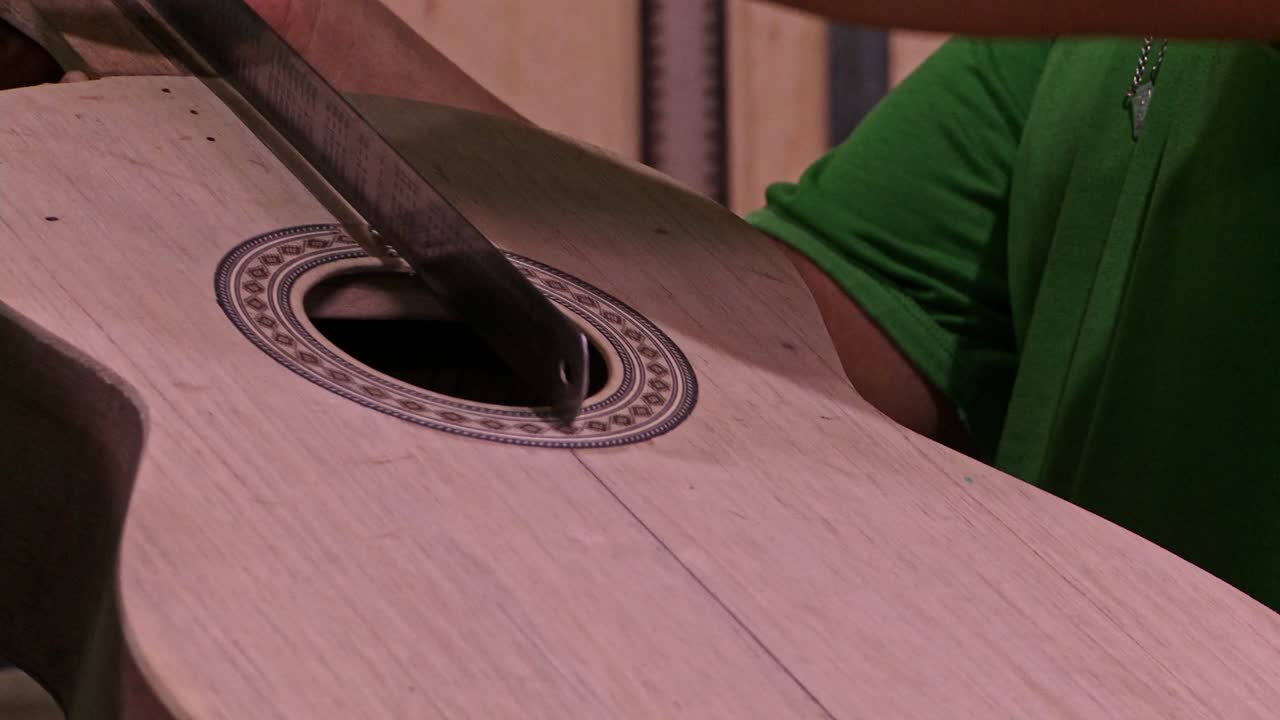 luthier marcando una guitarra acústica que está haciendo