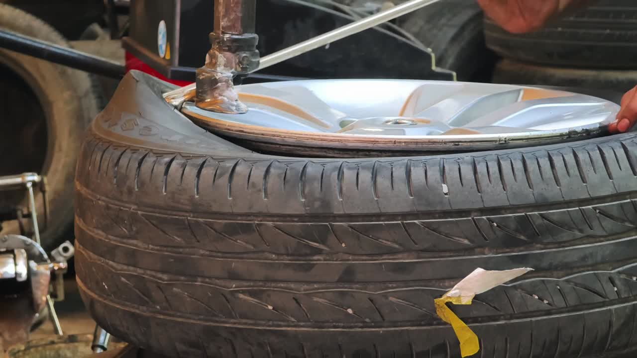 Mechanic Changing Car Tire on a Machine in a Garage