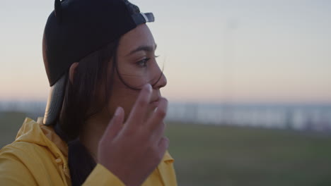 Primer-Plano-Retrato-De-Una-Joven-Adolescente-Que-Parece-Contemplativa-Disfrutando-Del-Tranquilo-Día-Del-Atardecer-En-El-Parque-Costero,-Viento-Que-Sopla-El-Pelo-En-Cámara-Lenta