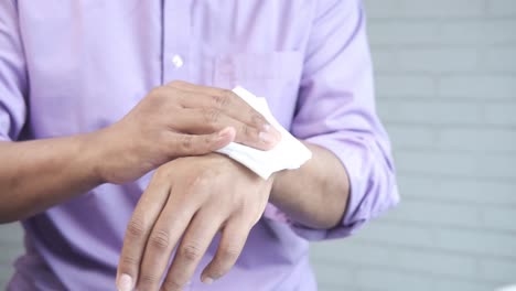 man cleaning hands with tissue