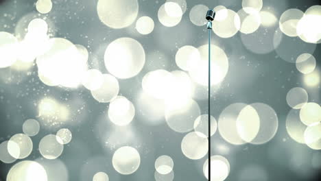 retro metallic microphone against spots of light against grey background