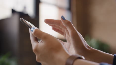 close up of woman's hands using smart phone at home