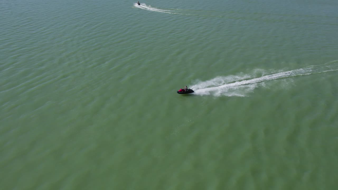 Jeździec na szybkim skuterze wodnym Sea Doo na jeziorze w słoneczny letni dzień - Ujęcie z lotu ptaka