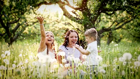 happy mother and kids playing with dandelions