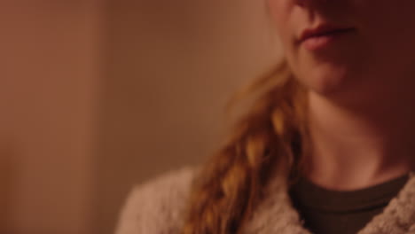 girl looking down, and cooking in the background