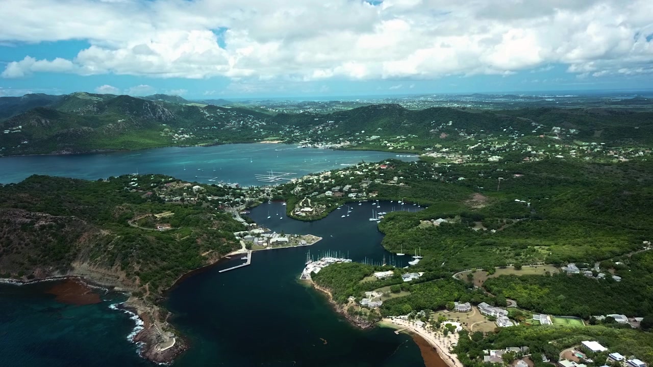 Ripresa aerea con drone che domina l'isola paradisiaca di Antigua, giornata di sole