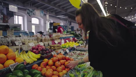 Frau-Auf-Dem-Markt,-Die-An-Einem-Stand-Mandarinen-Auswählt