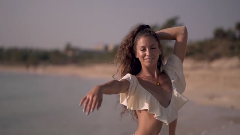 Girl-On-Tropical-Island-Smiling-On-Beach-While-Waves-Hit-The-shore