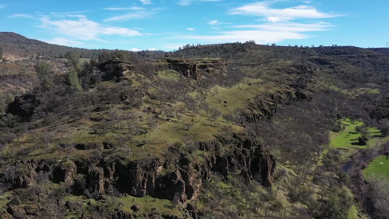 imágenes de drones que vuelan hacia las líneas de los acantilados de las montañas con un exuberante crecimiento verde y árboles que crecen en las mesetas