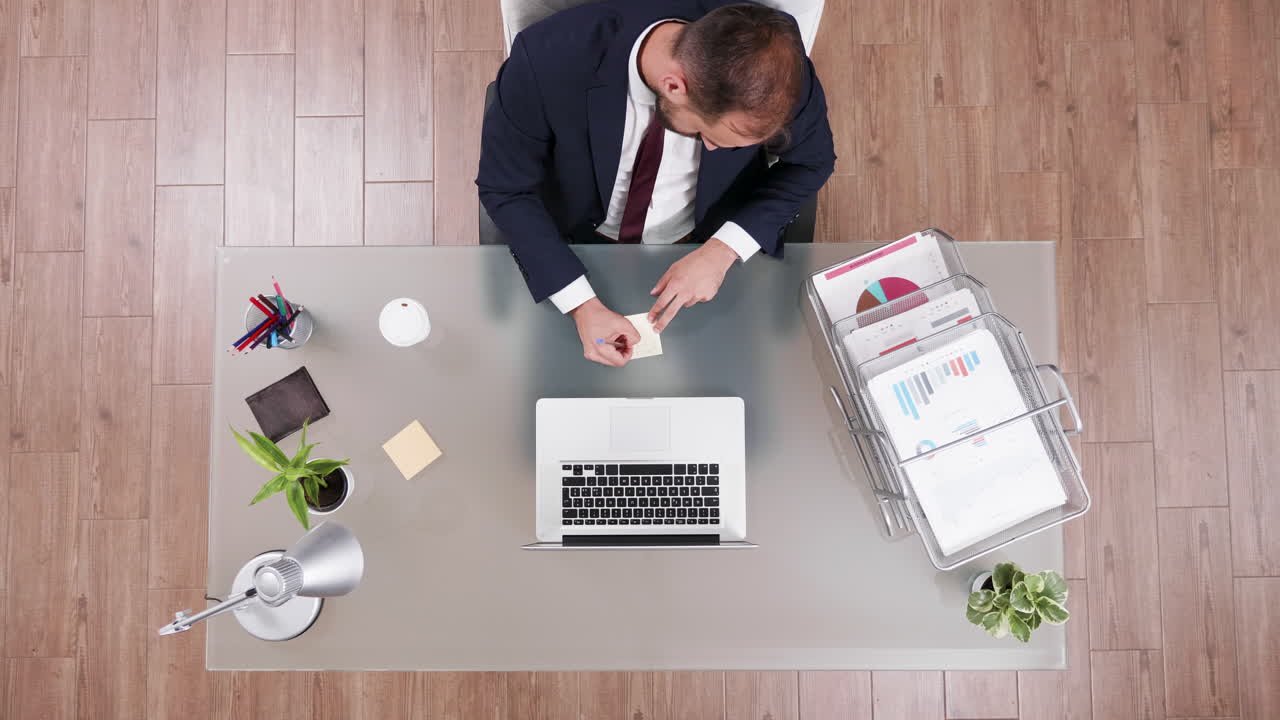 Businessman working at desk with laptop and documents