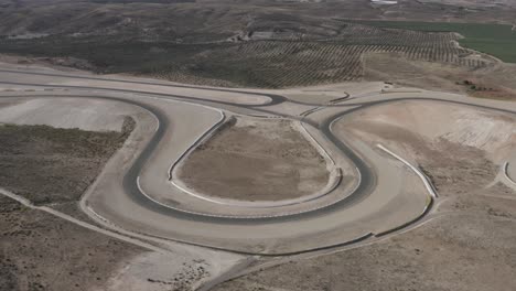 single bend in almeria race track in spain surrounded by desert and olive trees