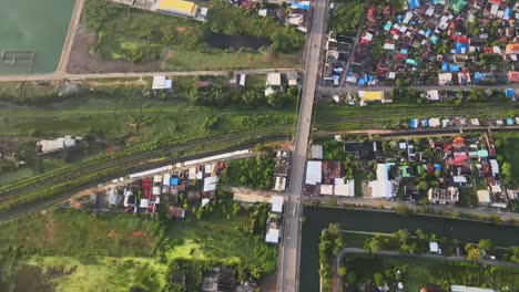 aerial: drone flies forward along the highway which separates the asian village, nakhon ratchasima town in korat province, thailand asia