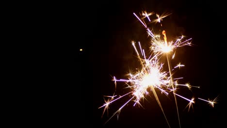 new year's sparklers are lit by flames.