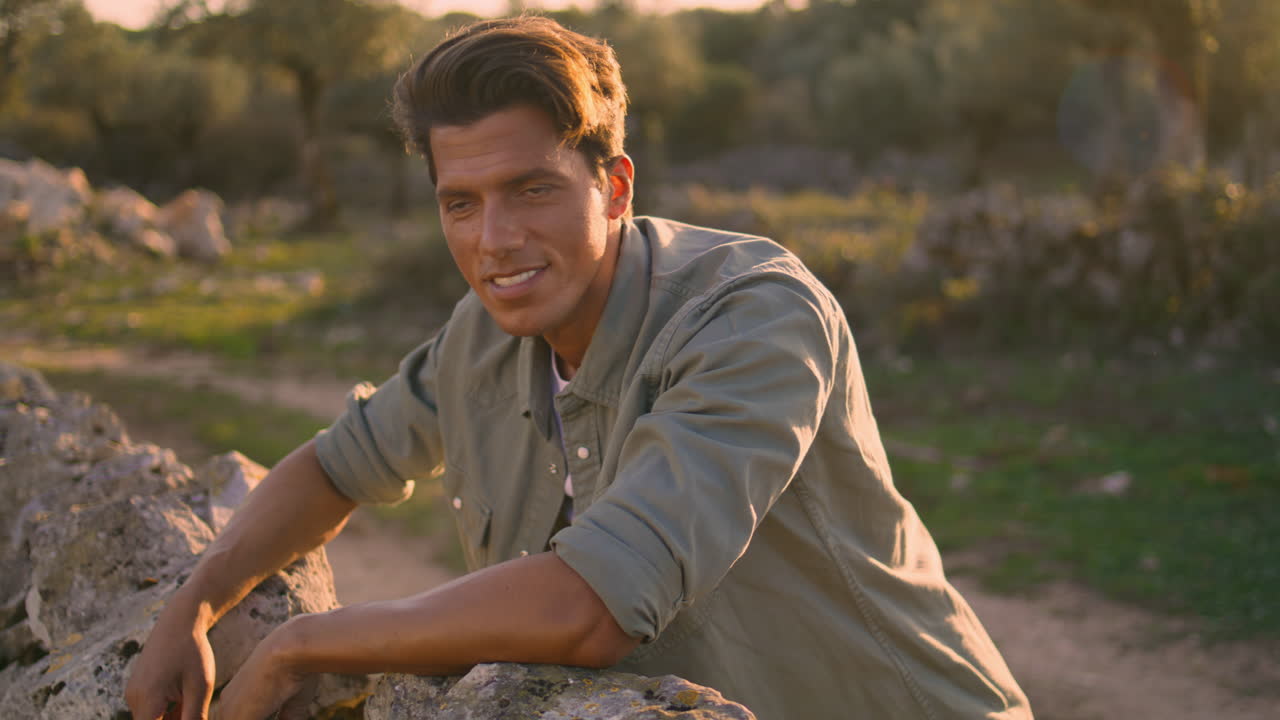 hombre positivo posando cámara luz del sol retrato de la naturaleza. tipo inclinado cerca vertical