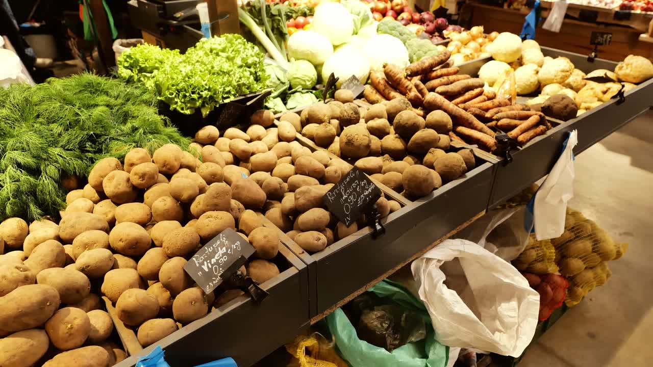 Assorted root vegetables leafy greens arranged at cozy indoor food stall, Latvia