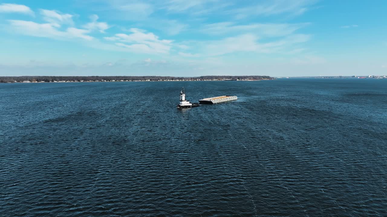 lago muskegon en invierno con un gran remolcador tirando de una barcaza