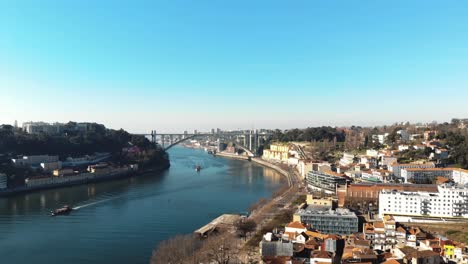 douro riverbank with arrábida bridge on the horizon in porto, portugal - aerial shot
