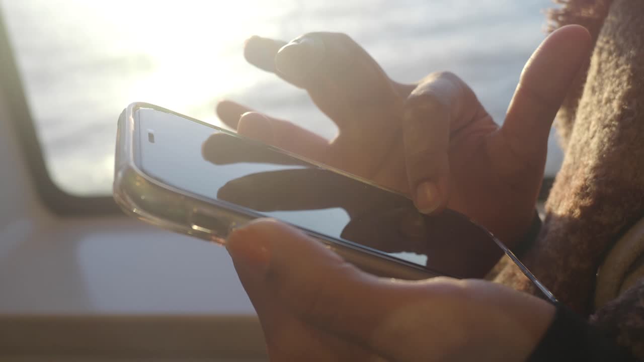 persona que utiliza un teléfono inteligente en un barco