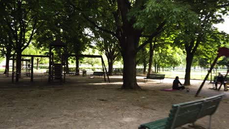 Ein-Blick-Durch-Die-öffentlichen-Gärten-Von-Mailand-Italien-Zeigt-Nur-Wenige-Menschen-Mit-Gesichtsmaske-Und-Einen-Kinderspielplatz,-Der-Mit-Polizeiband-Nicht-Zugänglich-Ist