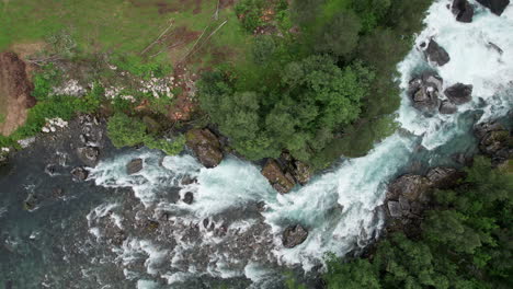 Top-down-aerial-view,-tracking-over-a-fast-flowing-river-in-Norway