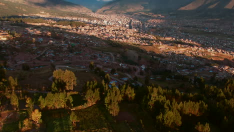 Antena-Sobre-Colinas-Revela-La-Ciudad-De-Cusco-Y-Las-Montañas-De-Los-Andes-En-Perú-Durante-La-Hora-Dorada